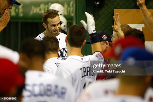 Evan Longoria of the Tampa Bay Rays is greeted by teammates in the dugout after hitting a home run in the sixth inning during the game against the...