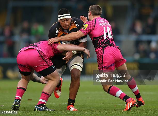 Nathan Hughes of Wasps is tackled by Pablo Henn and Will Robinson of London Welsh during the Aviva Premiership match between Wasps and London Welsh...