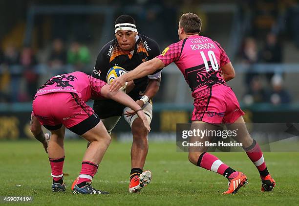 Nathan Hughes of Wasps is tackled by Pablo Henn and Will Robinson of London Welsh during the Aviva Premiership match between Wasps and London Welsh...