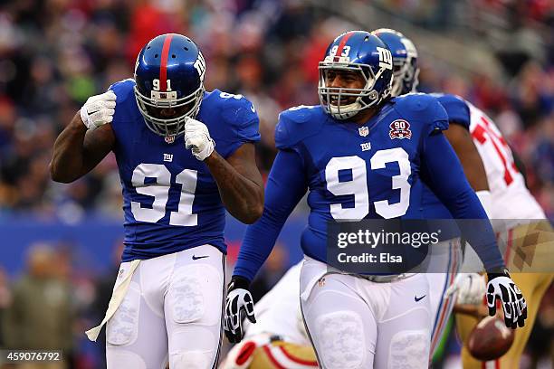 Robert Ayers of the New York Giants celebrates after sacking Colin Kaepernick of the San Francisco 49ers in the first quarter as Mike Patterson of...