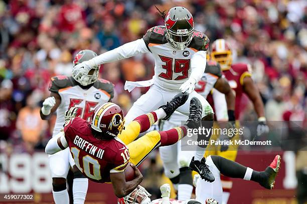 Quarterback Robert Griffin III of the Washington Redskins takes a second quarter hit from defensive back Brandon Dixon of the Tampa Bay Buccaneers at...