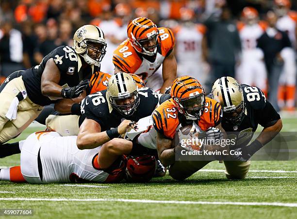 Akiem Hicks of the New Orleans Saints and John Jenkins tackle Jeremy Hill of the Cincinnati Bengals during the first quarter at Mercedes-Benz...