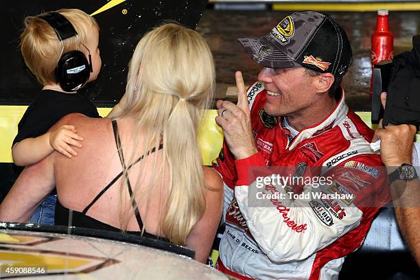 Kevin Harvick, driver of the Budweiser Chevrolet, celebrates with his wife DeLana and son Keelan in victory lane after winning during the NASCAR...