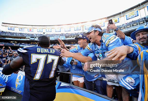 Fans celebrate with King Dunlap of the San Diego Chargers after their team defeated the Oakland Raiders 13-6 in the game at Qualcomm Stadium on...