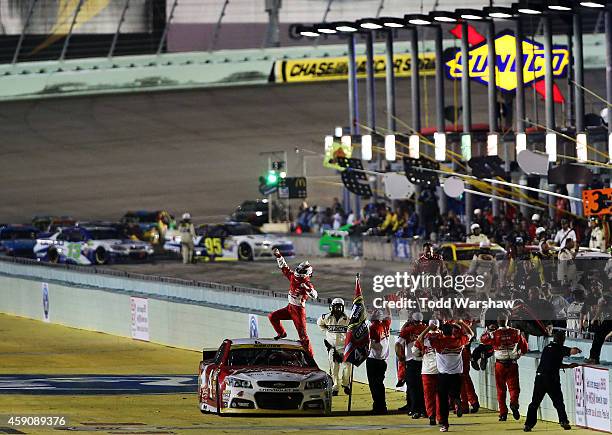 Kevin Harvick, driver of the Budweiser Chevrolet, celebrates with his team after winning the NASCAR Sprint Cup Series Ford EcoBoost 400 at...