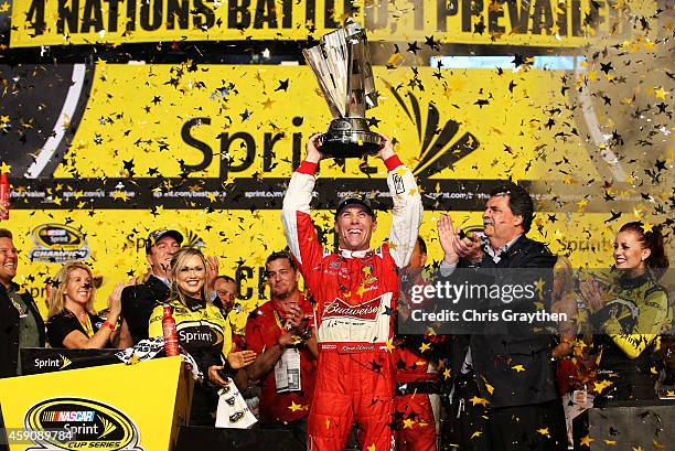 Kevin Harvick, driver of the Budweiser Chevrolet, celebrates with the trophy in victory lane after winning during the NASCAR Sprint Cup Series Ford...