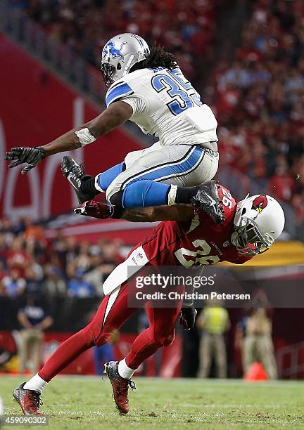 Running back Joique Bell of the Detroit Lions jumps over free safety Rashad Johnson of the Arizona Cardinals as he rushes the football during the...