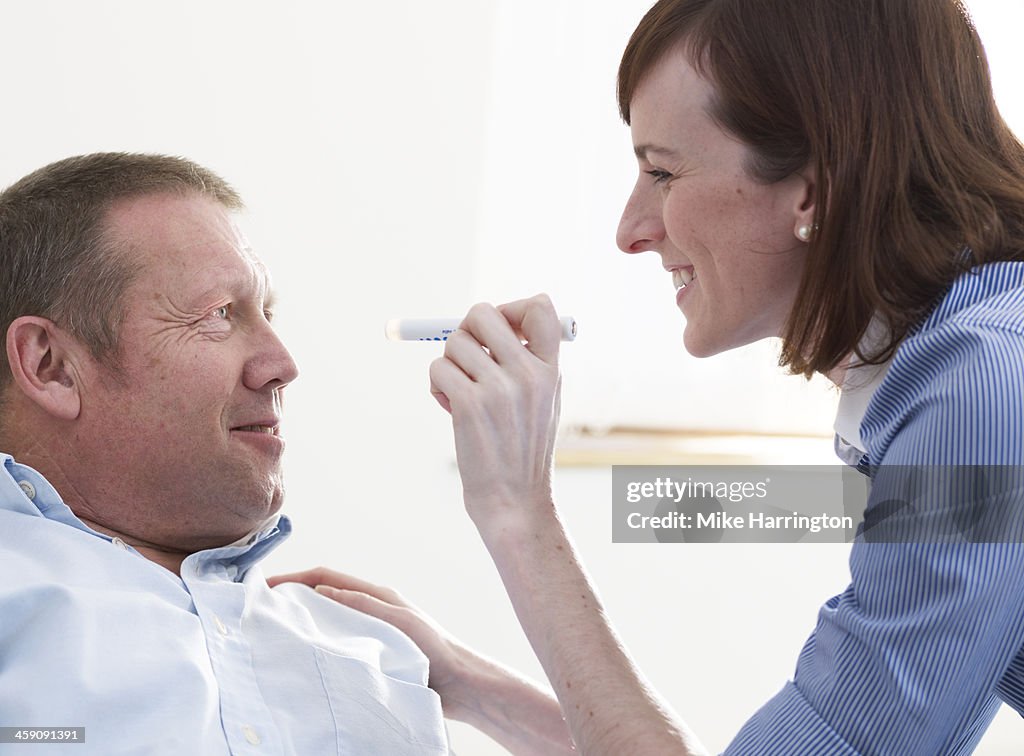 Doctor examining eyes of patient in practice.