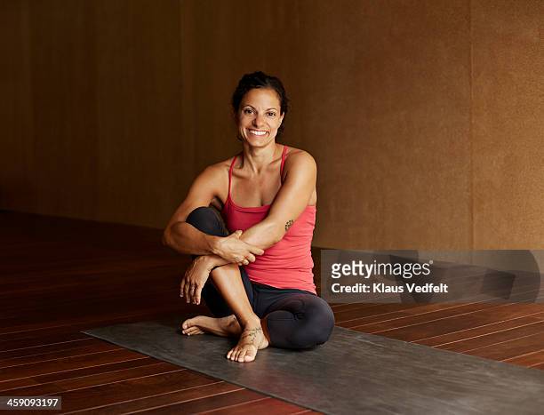 portrait of woman sitting in yoga studio - yoga instructor stock pictures, royalty-free photos & images
