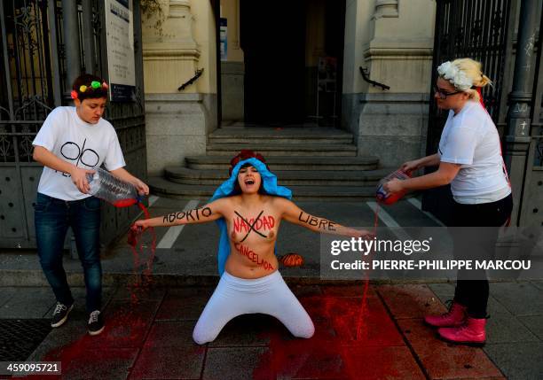 Three members of the protest group Femen protest in front of San Manuel y San Benito church in Madrid to decry Spain's plan to ban women from freely...