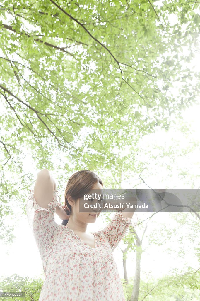 Woman adjusting her hair among trees