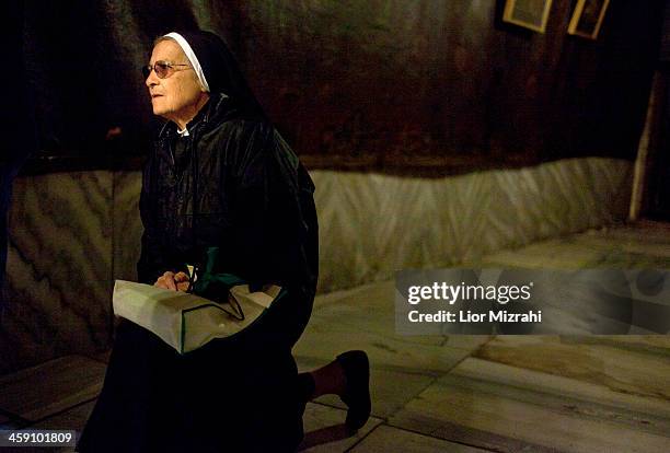 Nun prays at the Grotto in the Church of the Nativity on December 23, 2013 in Bethlehem, West Bank. Every Christmas pilgrims travel to the church...