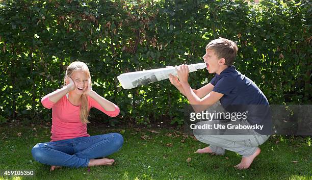 Fourteen-year-old boy yelling through a megaphone made out of rolled-up newspaper at his sister on August 11 in Duelmen, Germany. Photo by Ute...