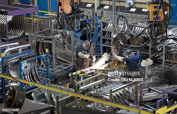 Members of Nissan's manufacturing staff weld vehicle panels in the Press Shop at the Sunderland Plant in North East England on November 12, 2014. The...