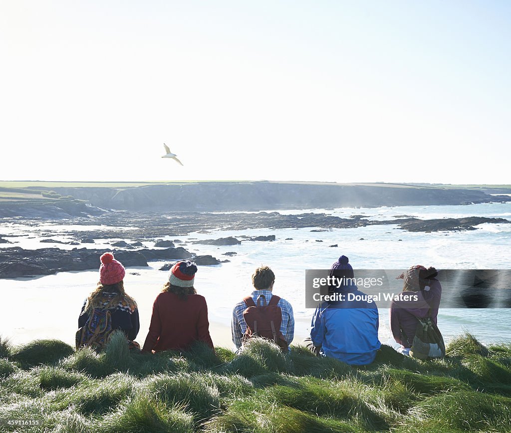 Group of friends sit on Atlantic coast.