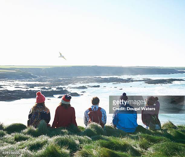 Group of friends sit on Atlantic coast.