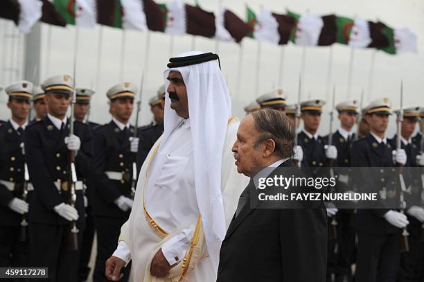 Algerian President Abdelaziz Bouteflika and the Emir of Qatar Hamad bin Khalifa al-Thani review the honour guard during a welcoming ceremony at...