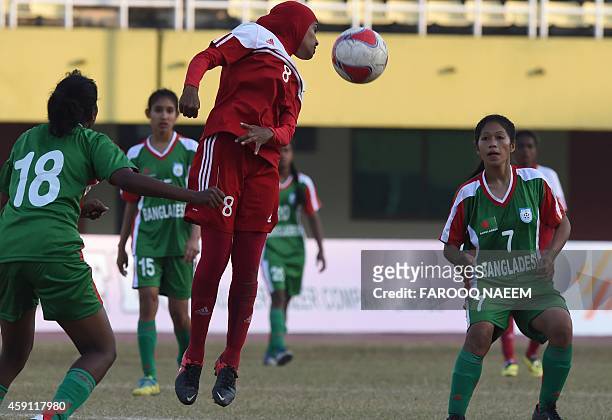 Bangladesh midfielder Maynu Marma and forward Mossamat Munmun Akter look on as Maldives forward Mariyam Rifa heads the ball during the final match of...