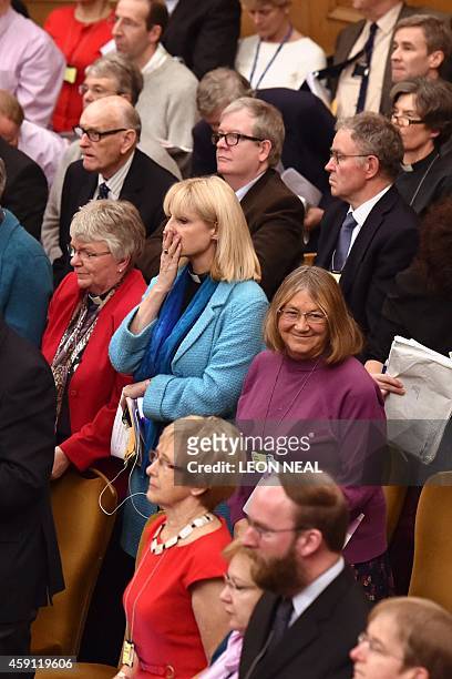 Members of the Church of England's Synod react after the show of hands to formalise the vote on the consecration of women bishops in central London...