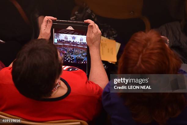 Member of the Church of England's Synod looks at a photograph of the voting process after formalising the vote on the consecration of women bishops...