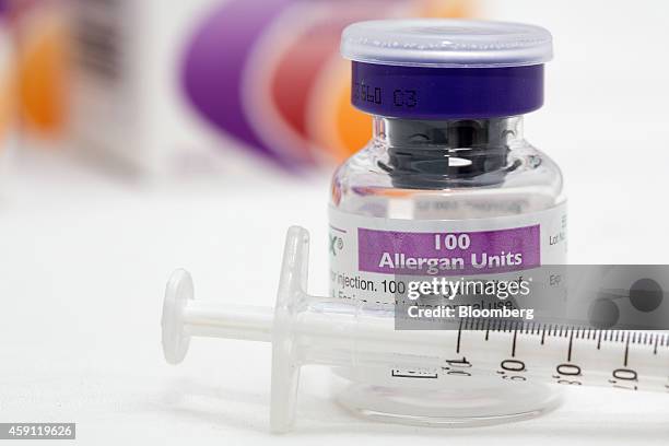 Syringe rests alongside a vial of Allergan Botox, produced by Allergan Inc., in this arranged photograph taken at a skin and beauty clinic in London,...