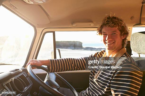 man sitting in camper van beside coast. - wavy hair beach stock pictures, royalty-free photos & images