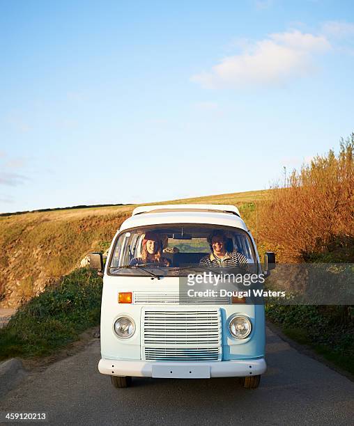 couple driving camper van along coastal road. - driver front view stock pictures, royalty-free photos & images