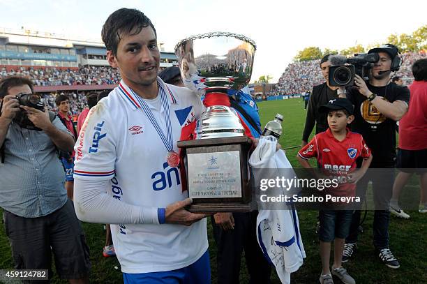 Gonzalo Porras of Nacional holds the trophy after winning a match between Cerro and Nacional as part of round 13 of Campeonato Apertura 2014 at Gran...