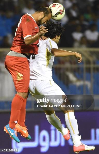 Amjad Raki Iraq's Amjad Radhi fights for the ball against Oman's Jaber al-Owaisi ...