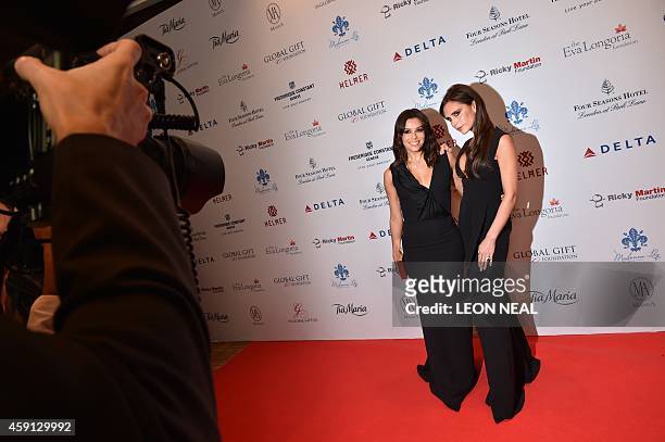 Actress Eva Longoria and British fashion designer Victoria Beckham pose as they arrive at the 5th annual London Global Gift Gala in London on...
