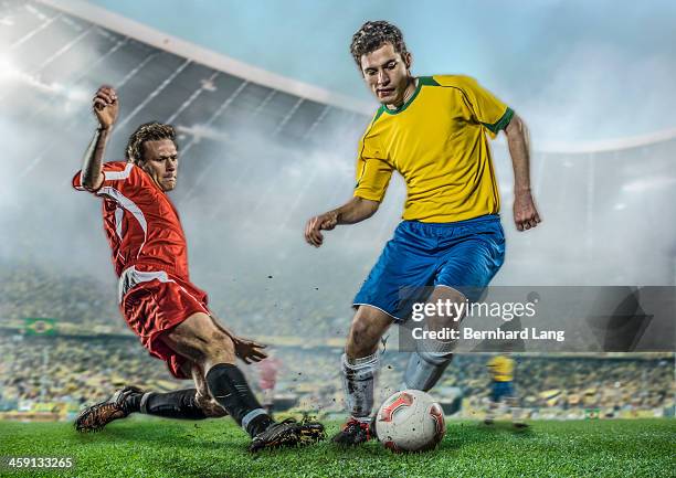 two soccer players fighting for ball in stadium - football player tackle stock pictures, royalty-free photos & images