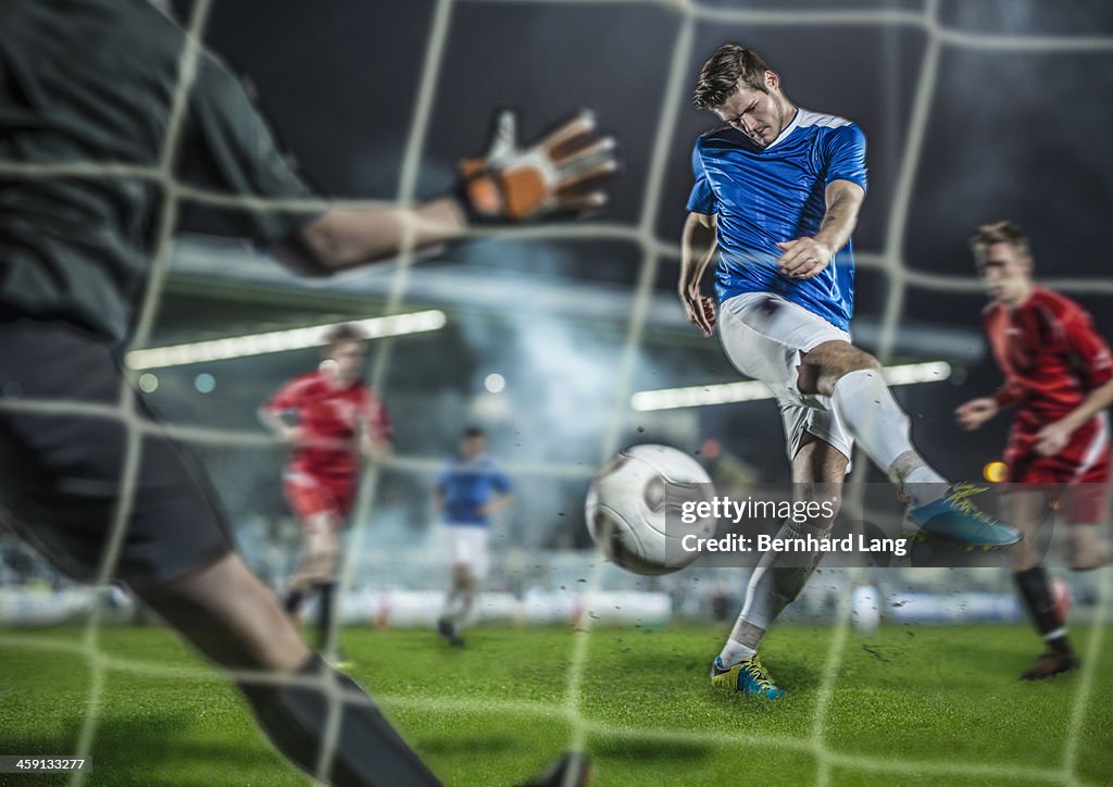 Soccer player kicking ball at goal