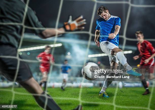 soccer player kicking ball at goal - kicking goal stock pictures, royalty-free photos & images