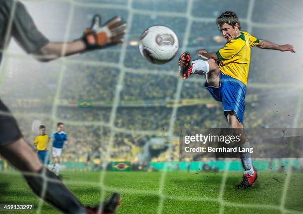 brazilian soccer player kicking ball at goal - soccer goal stock-fotos und bilder