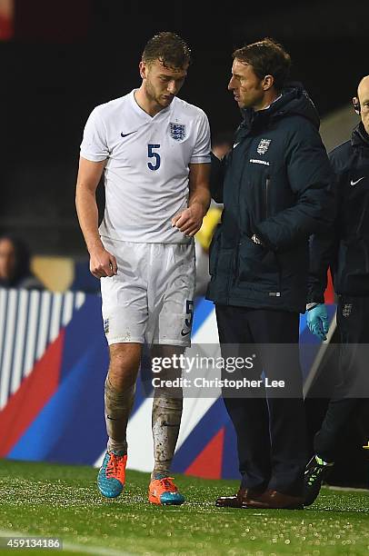 Ben Gibson of England leaves the field with a possible injury as he talks to manager Gareth Southgate during the U21 International Friendly match...