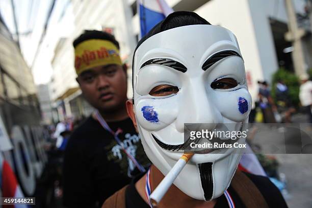 An anti-government protester wearing a Guy Fawkes mask poses for a photo outside a besieged police station near the venue of candidate registration...
