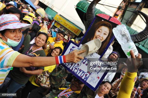 Anti-government protesters hit an image of Thai Prime Minister Yingluck Shinawatra outside a besieged police station near the venue of candidate...