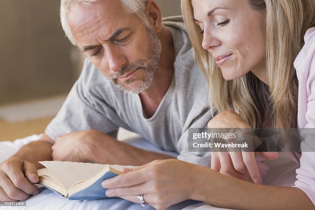 Mature couple reading book together