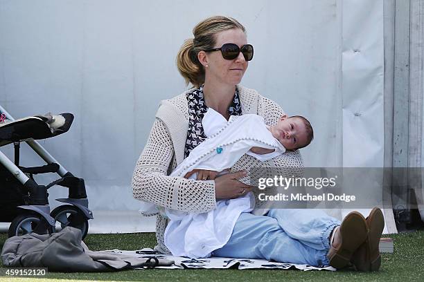 Tara Hendry, wife of golfer Michael Hendry of New Zealand, rests with her baby ahead of the 2014 Australian Masters at The Metropolitan Golf Course...