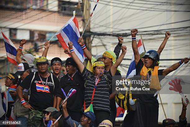 Anti-government protesters cheer as they besiege a police station near the venue of candidate registration for Thailand's upcoming election on...