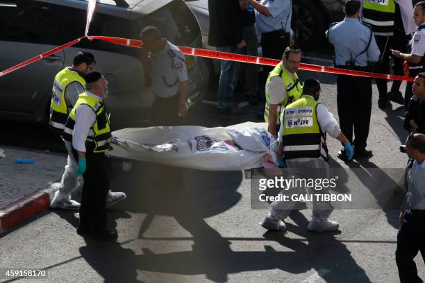 Israeli Zaka emergency services volunteers carry the body of one of the two Palestinian assailants who were shot dead while attacking a synagogue in...