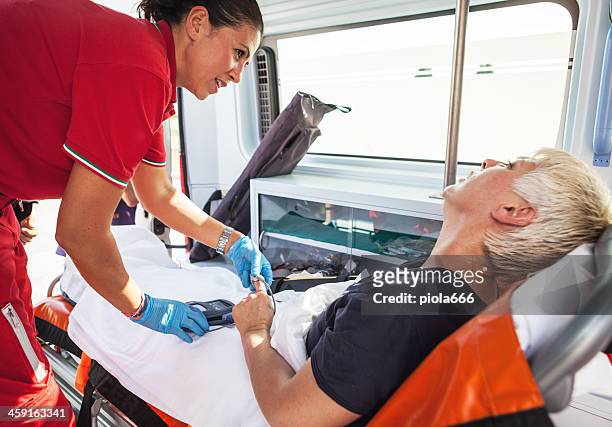 medical emergency team: in the ambulance - red cross stock pictures, royalty-free photos & images