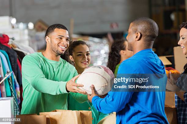 homem de aceitar que a turquia doação durante férias comida drive - food drive - fotografias e filmes do acervo