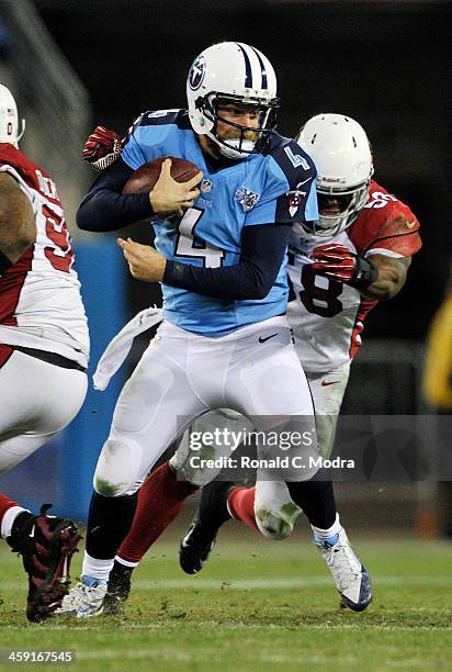 Quarterback Ryan Fitzpatrick of the Tennessee Titans scrambles as linebacker Daryl Washington tries to tackle him during a NFL game at LP Field on...