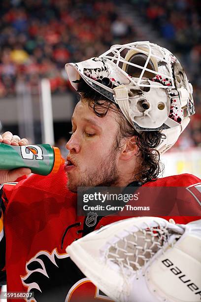 Karri Ramo of the Calgary Flames gets a drink during a stoppage in play against the Carolina Hurricanes at Scotiabank Saddledome on December 12, 2013...
