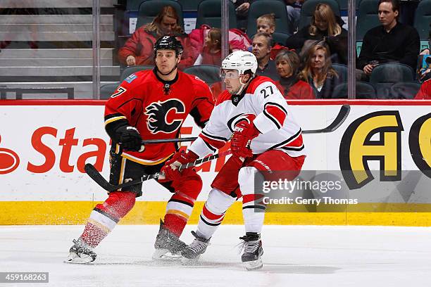 Lance Bouma of the Calgary Flames skates against Justin Faulk the Carolina Hurricanes at Scotiabank Saddledome on December 12, 2013 in Calgary,...