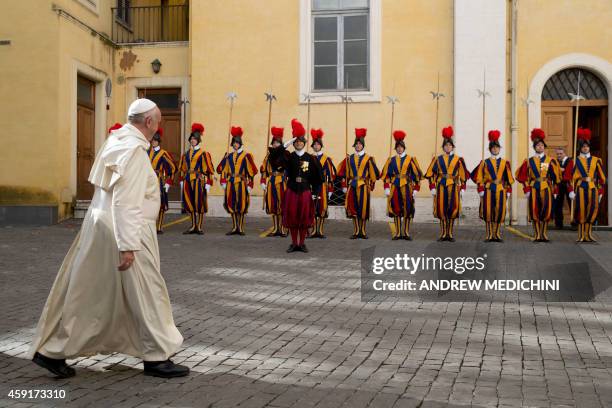 Pope Francis leaves past Swiss guards at the end of a private audience with Senegal's President Macky Sall at the Vatican, on November 18, 2014. AFP...