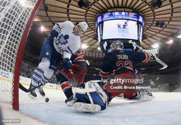 James van Riemsdyk of the Toronto Maple Leafs gets tripped up in front of Cam Talbot of the New York Rangers at Madison Square Garden on December 23,...