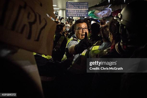 Police officer screams at pro-democracy activists as clashes broke out in front of the Legislative Council building on November 19, 2014 in Hong...