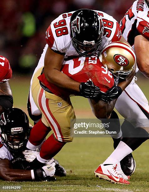 Running back Kendall Hunter of the San Francisco 49ers is tackled by defensive end Cliff Matthews of the Atlanta Falcons during a game at Candlestick...